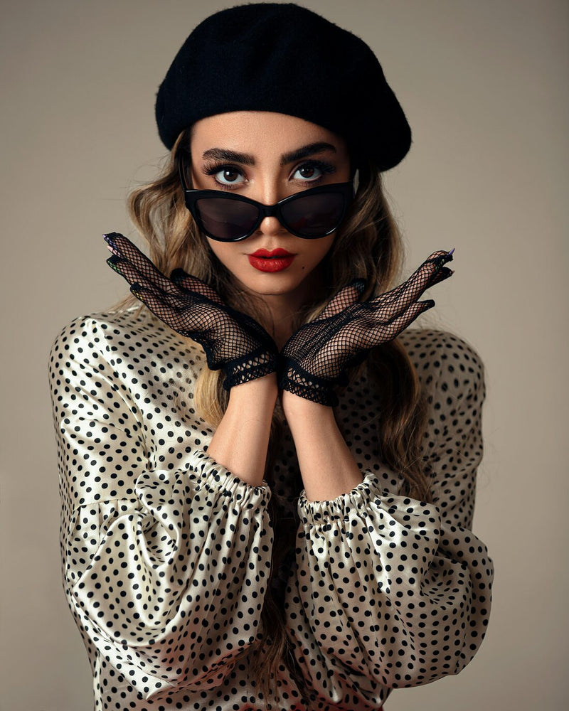Woman in a black beret wearing black cat-eye sunglasses
